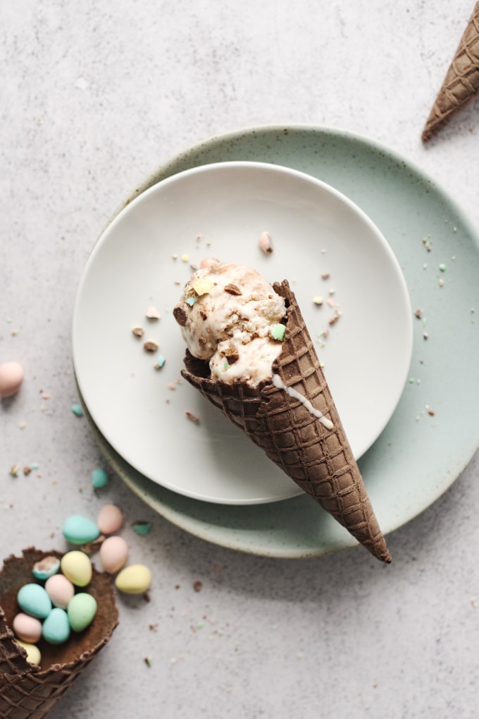 Chocolate waffle cones with ice cream and mini eggs on plates