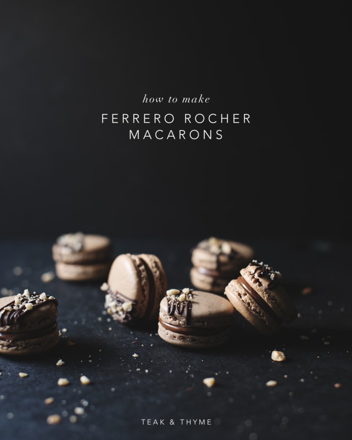 Ferrero Rocher macarons topped with dark chocolate drizzle and crushed hazelnuts scattered on a black background