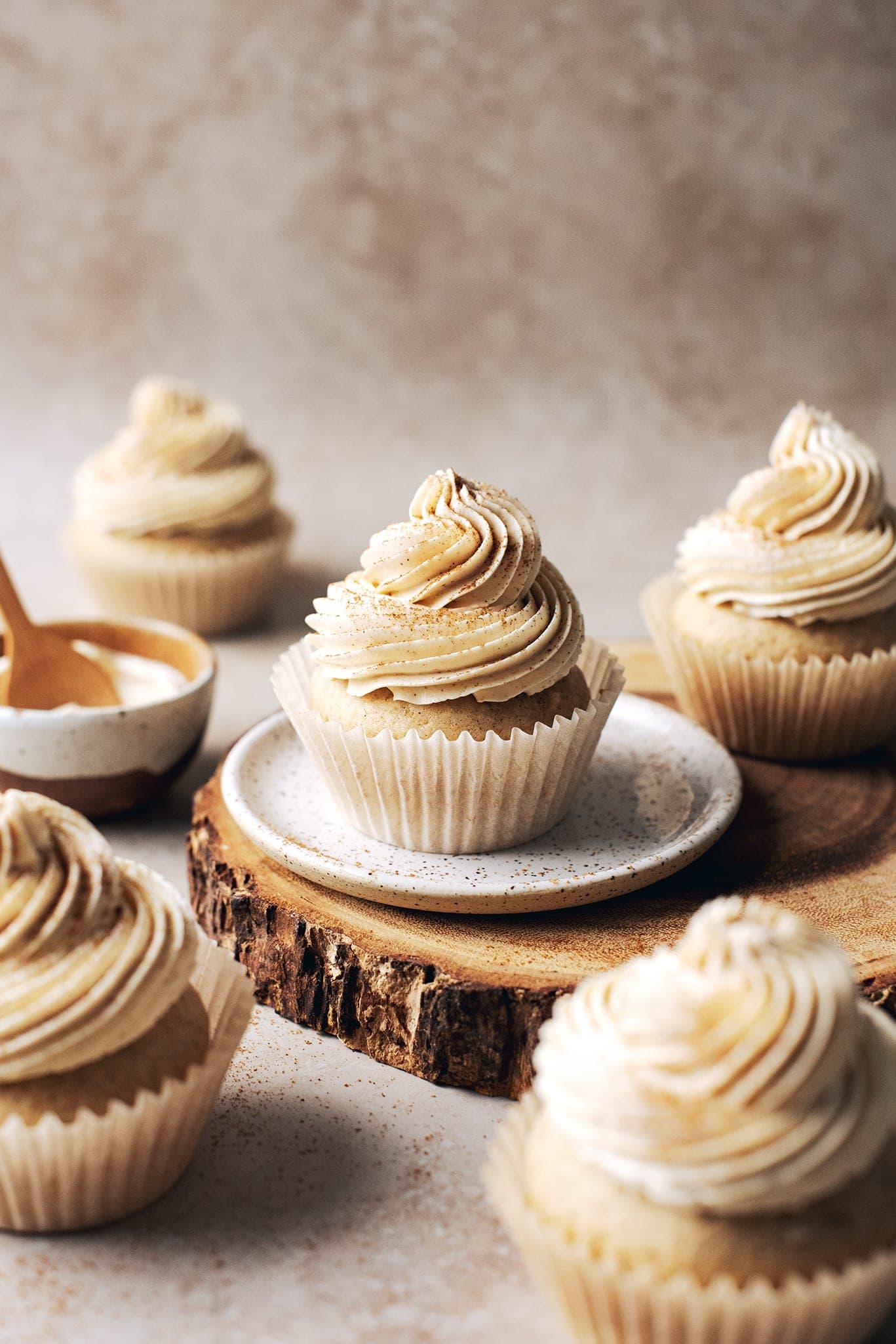 chai spice cupcakes scattered around a wood platter