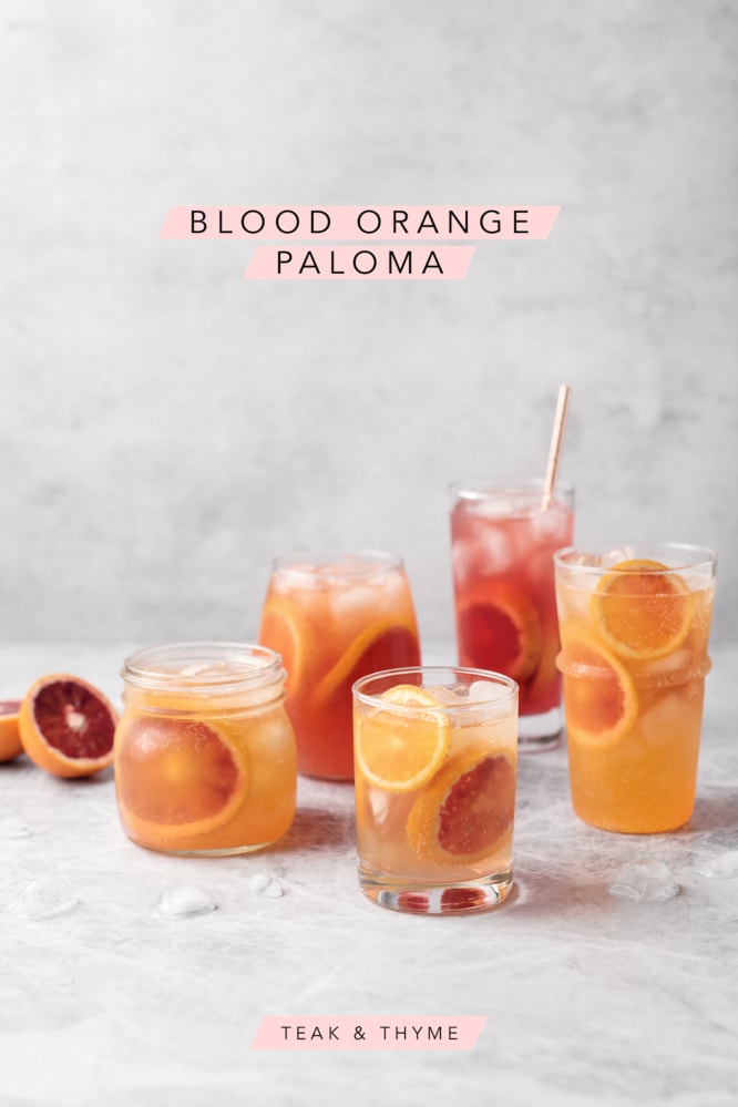 Five glasses of blood orange palomas on a grey background