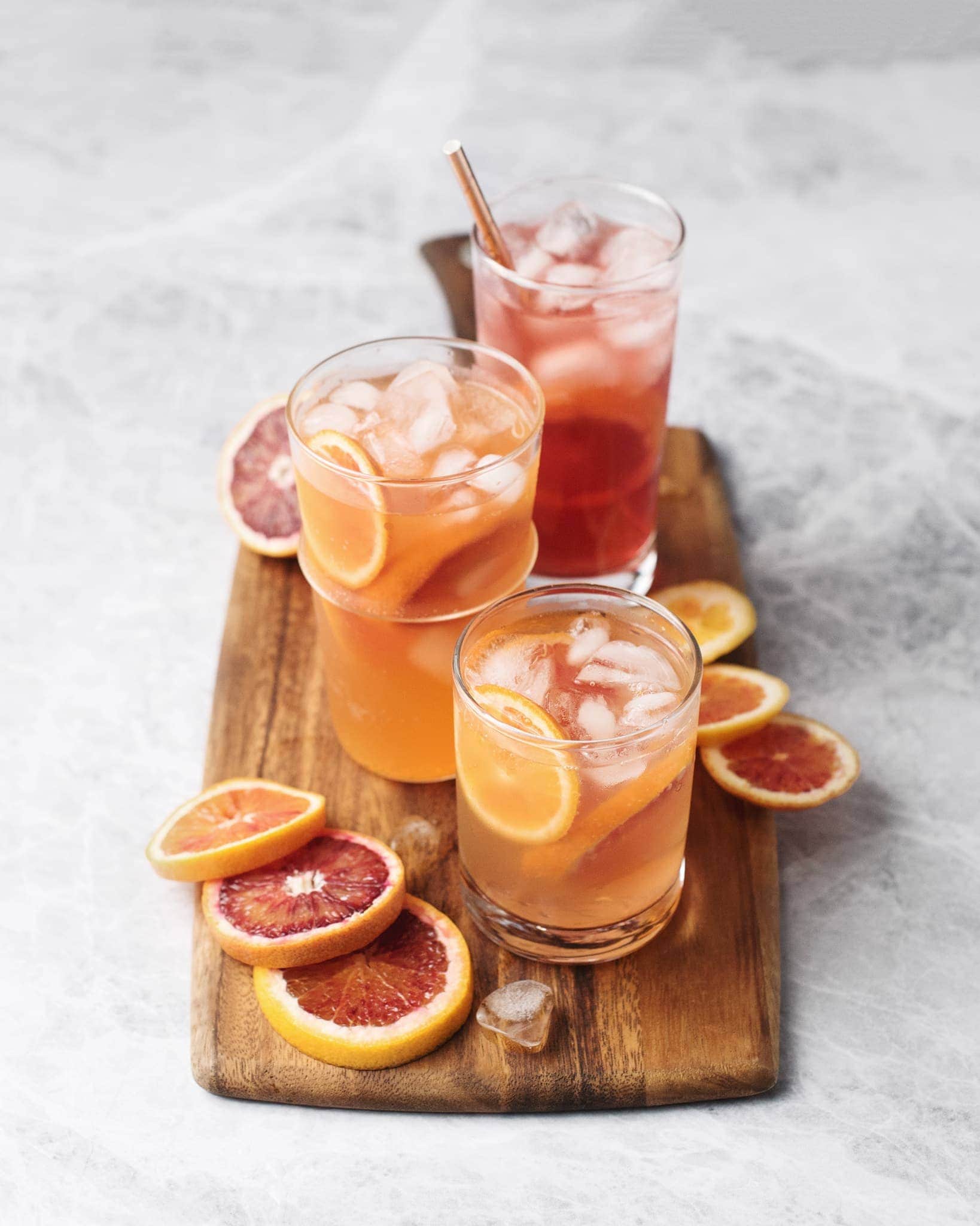 Glasses of blood orange palomas on a wooden serving board