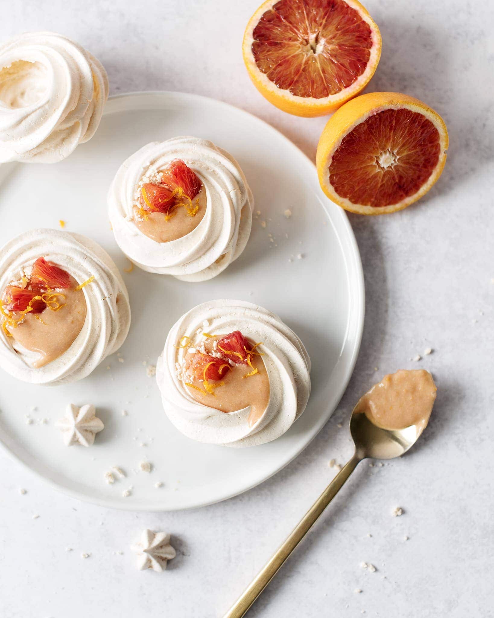 Overhead shot of a plate of blood orange curd pavlovas