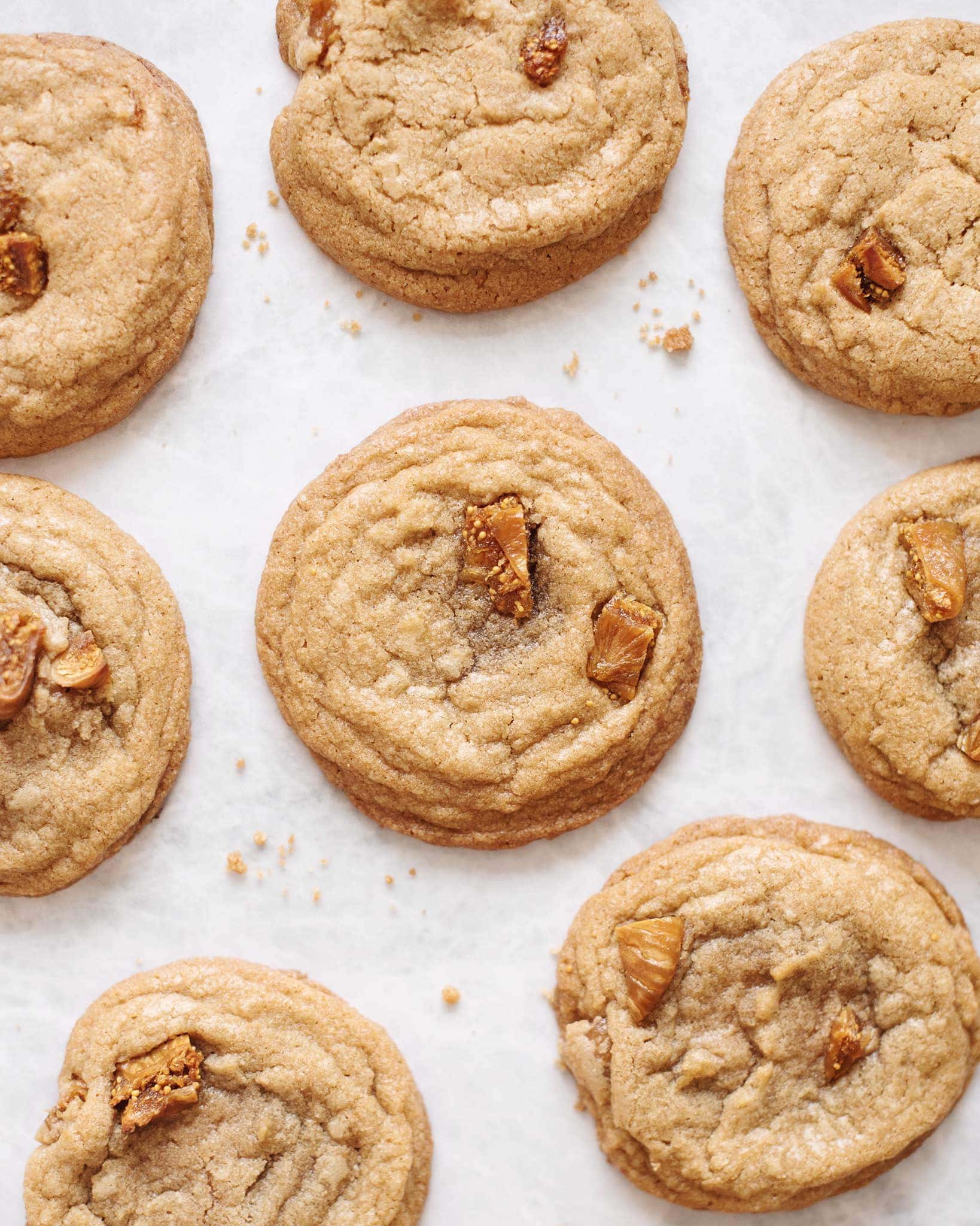Several fig and speculoos cookie butter cookies scattered on a grey background