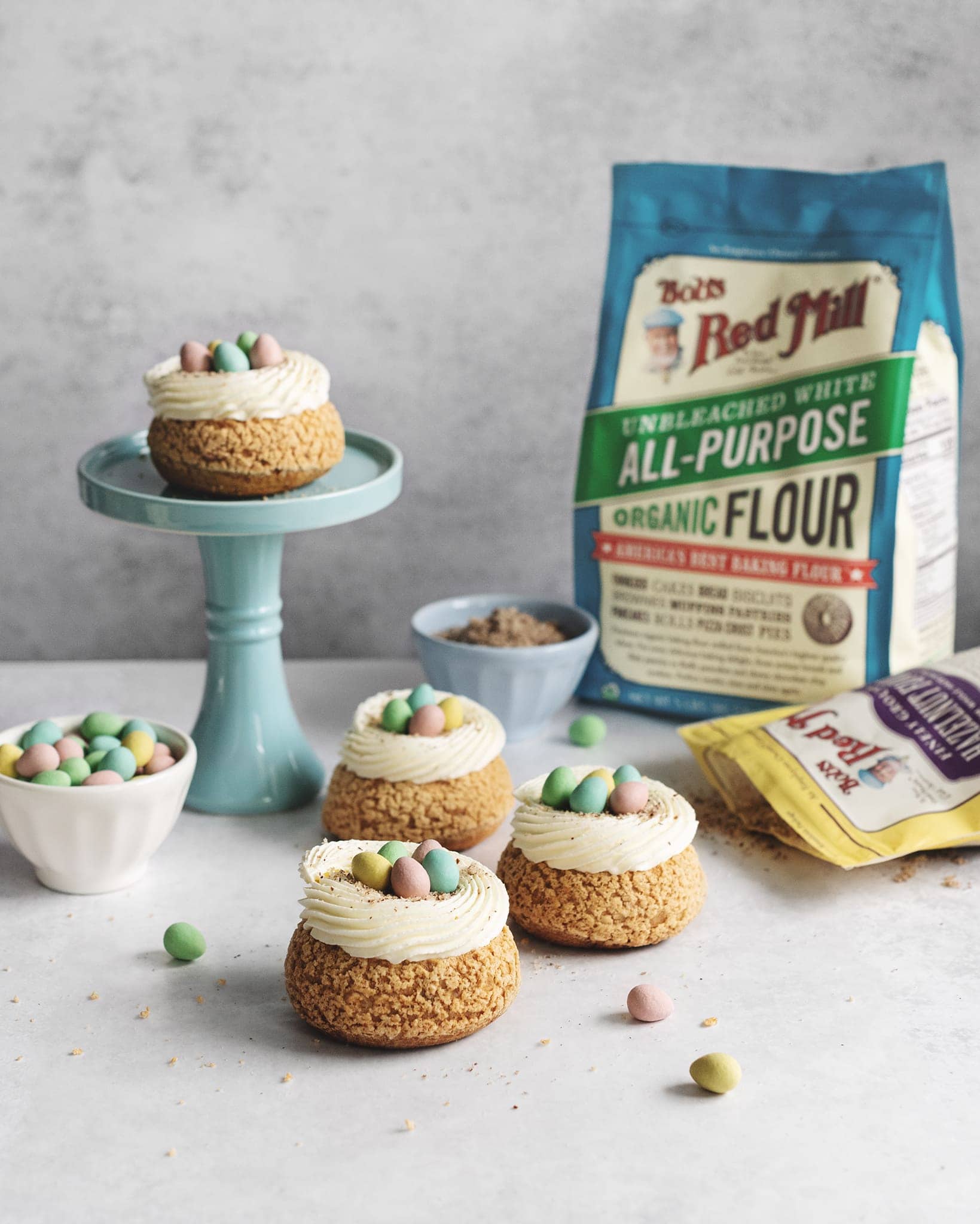 Cream puffs on cake stand with bag of flour in background