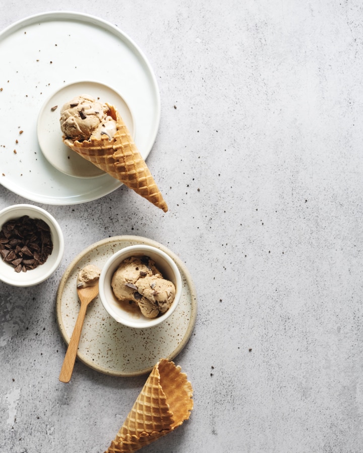 Overhead view of coffee ice cream cone on white plates