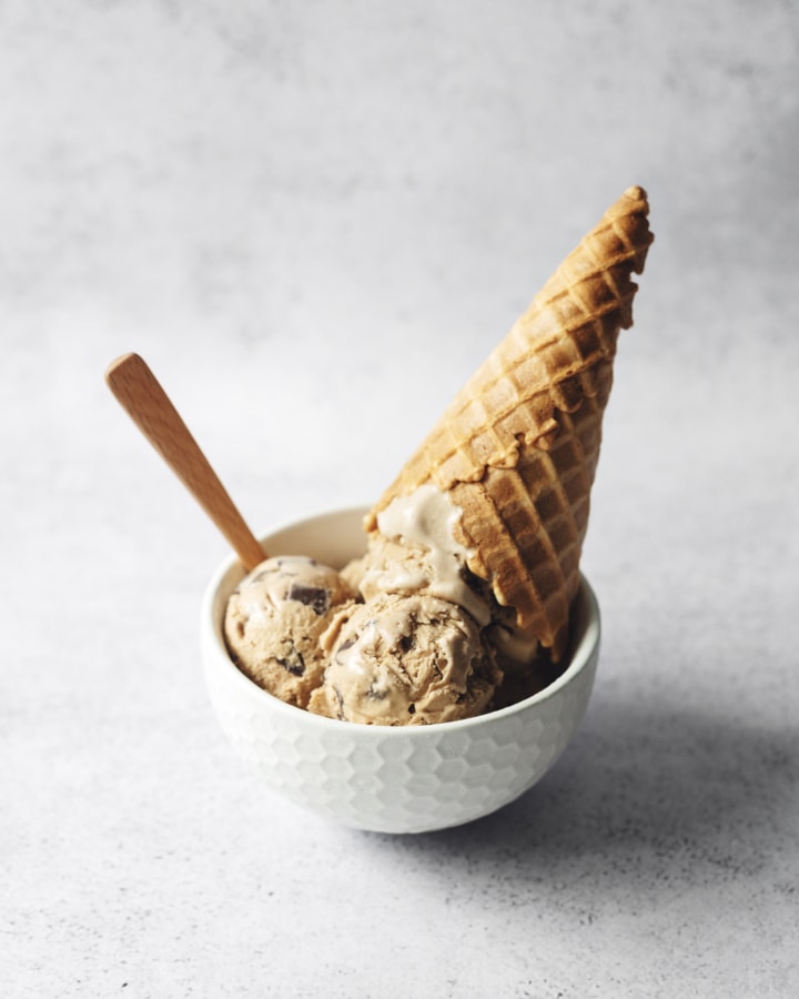 A bowl of coffee ice cream with upside down waffle cone