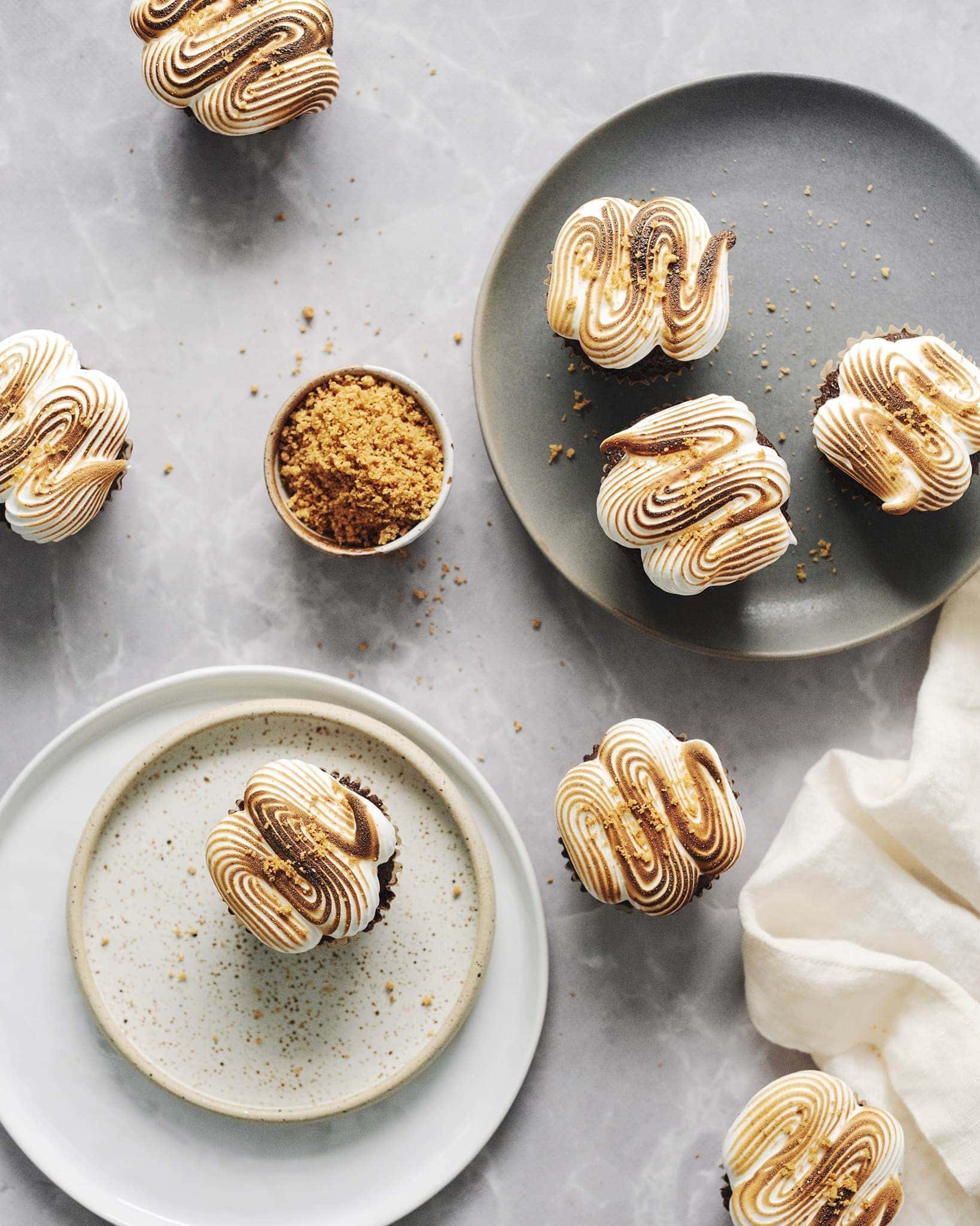 Overhead view of several s'mores cupcakes on grey background