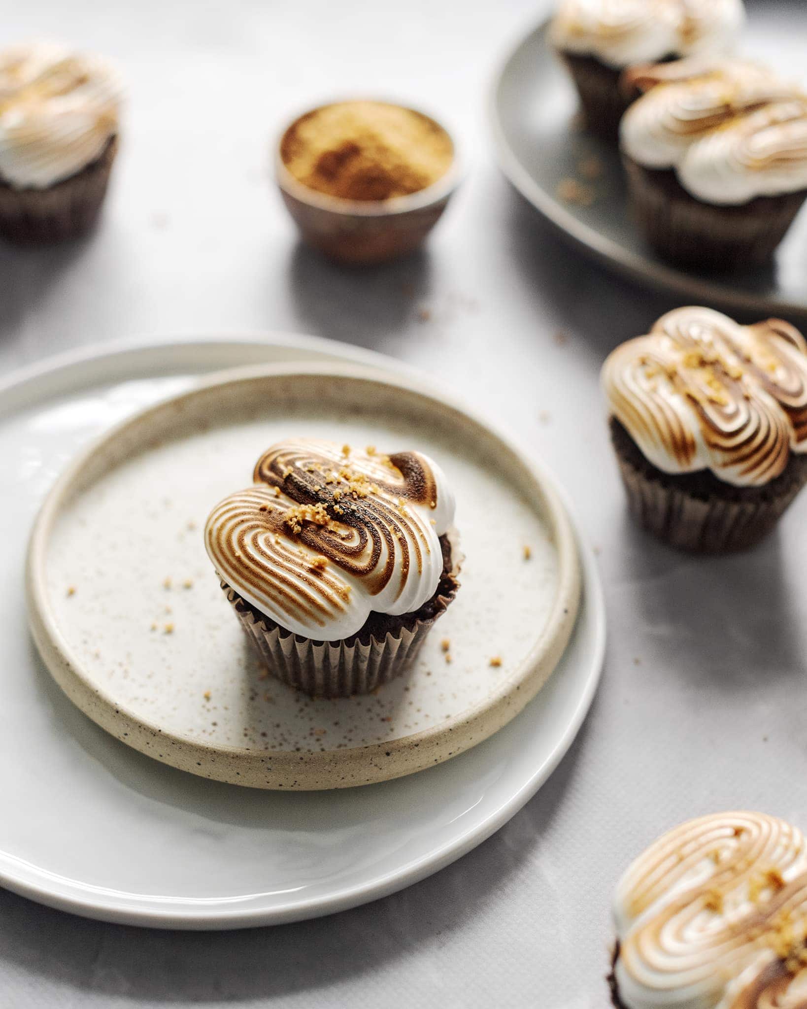 S'mores cupcakes with toasted marshmallow meringue on two plates