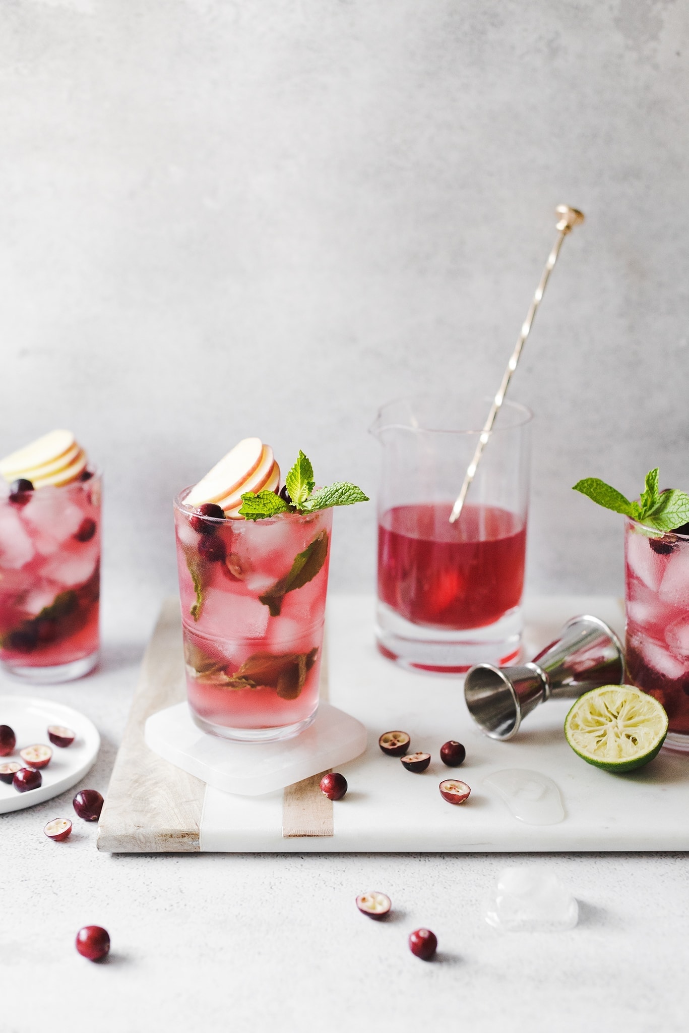 Cranberry apple mojitos on a marble and wood serving tray