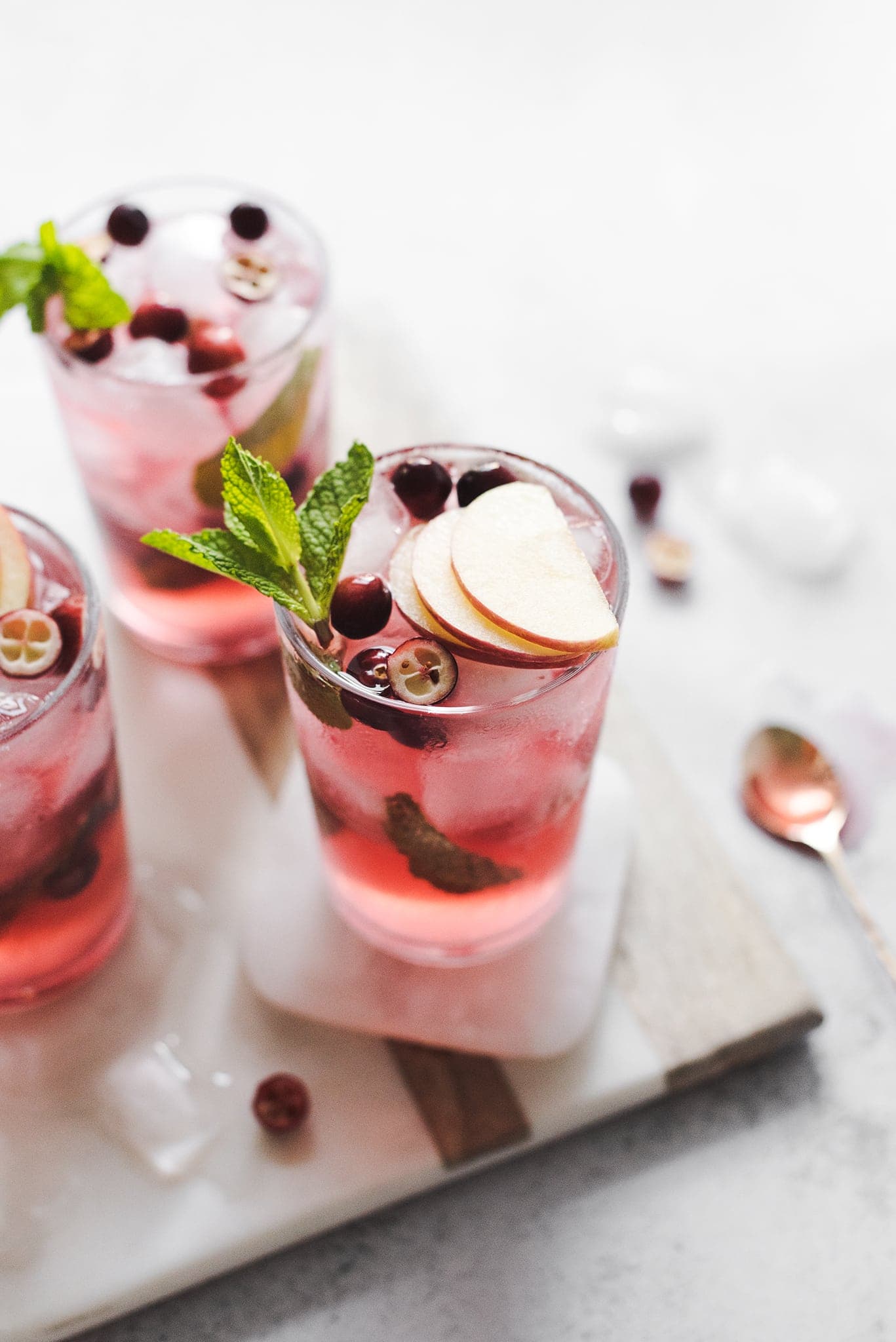 Cranberry apple mojitos topped with apple slices and mint