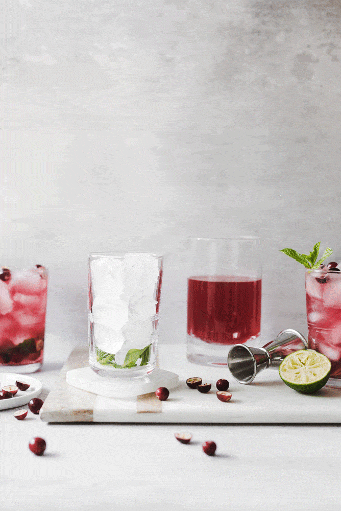 Pouring cranberry apple mojito into glass of ice