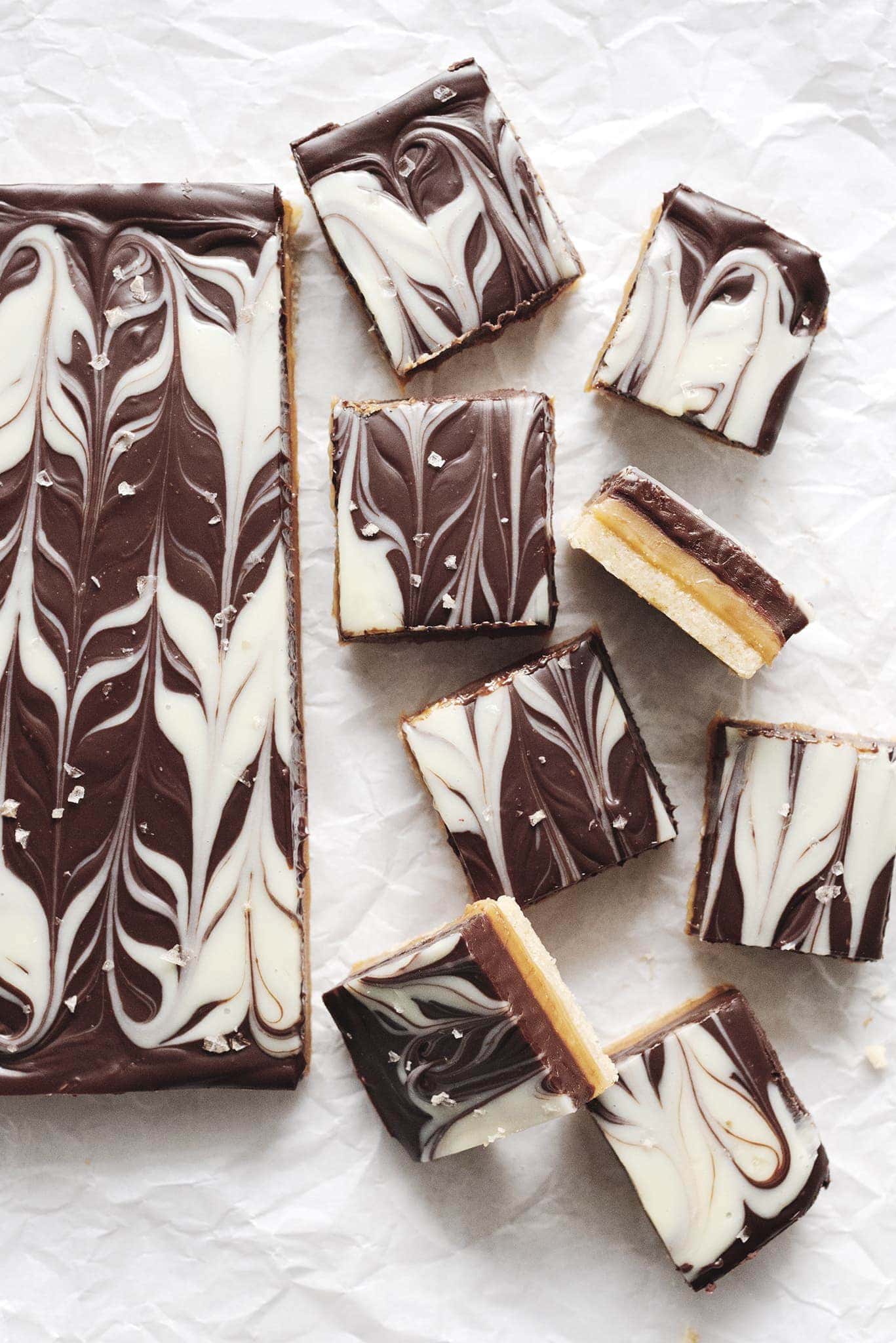 Squares of millionaire's shortbread bars on parchment paper