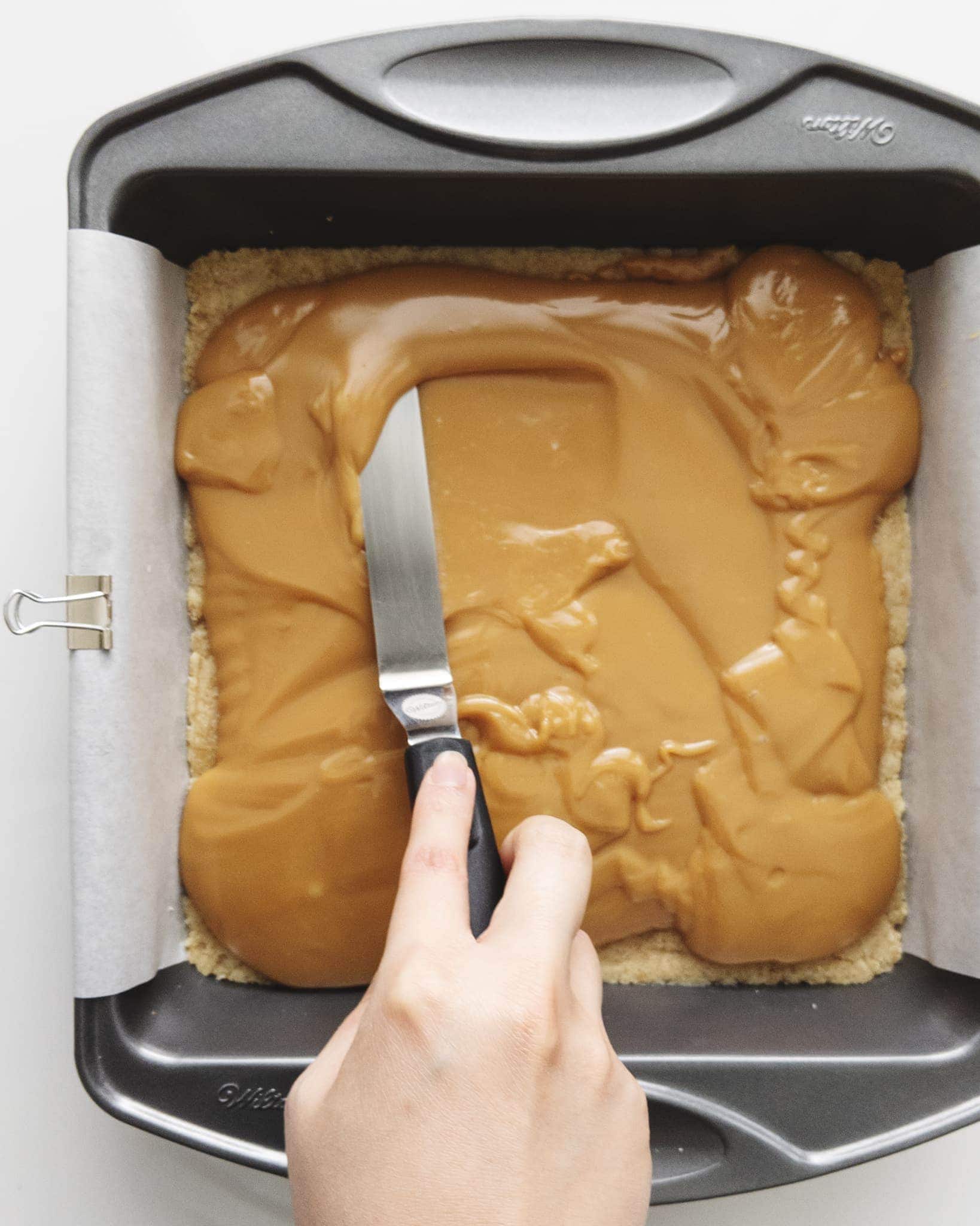 Spreading caramel across shortbread base
