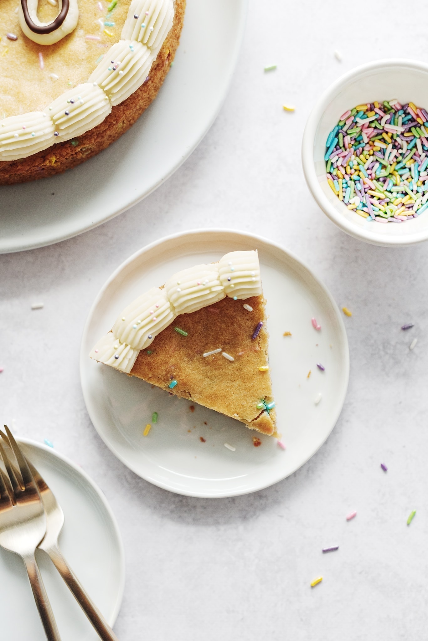 A slice of cake on a plate with sprinkles