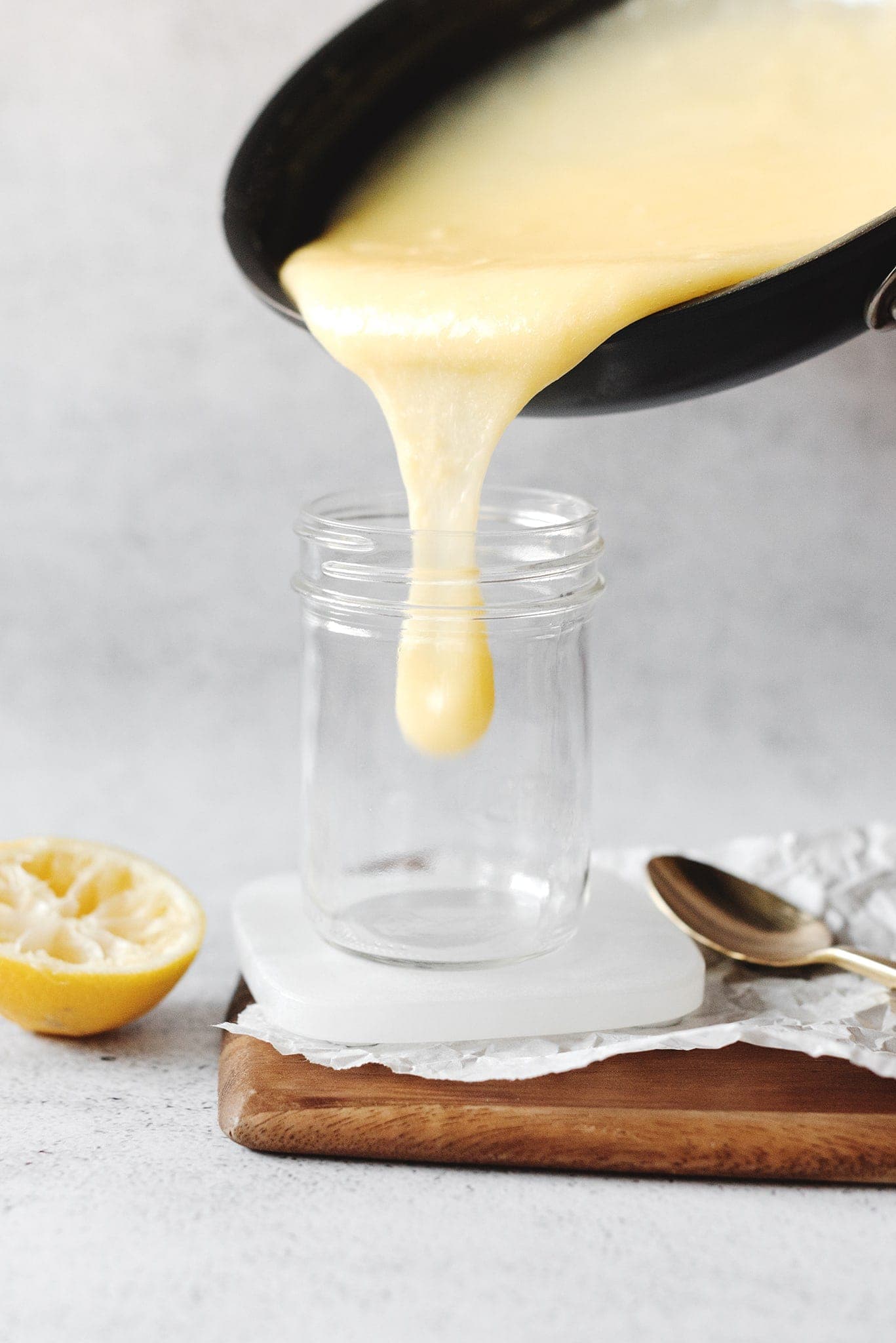 Pouring curd from pan to glass jar