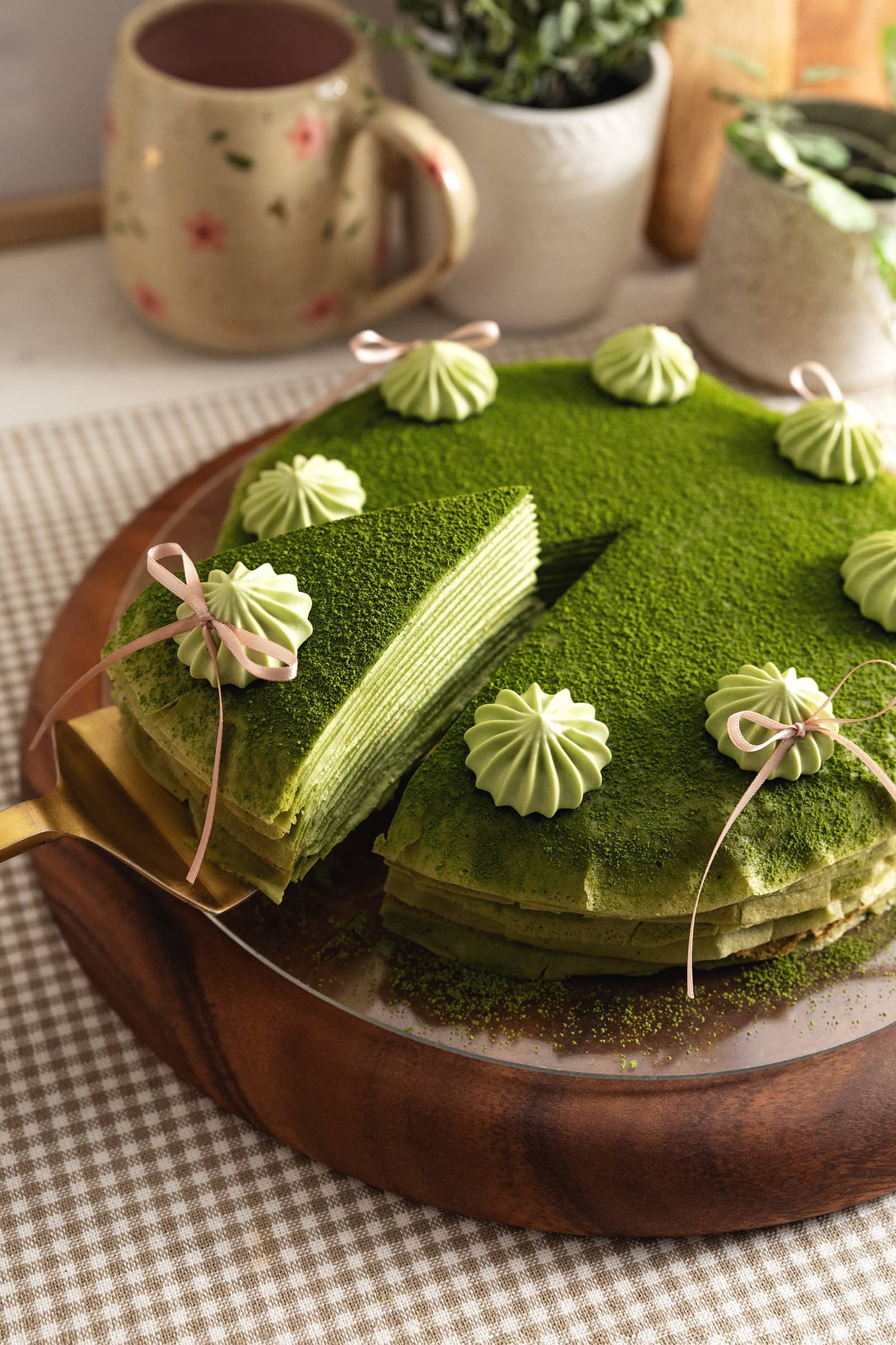 A slice of matcha crepe cake being slightly lifted from the rest of the cake.