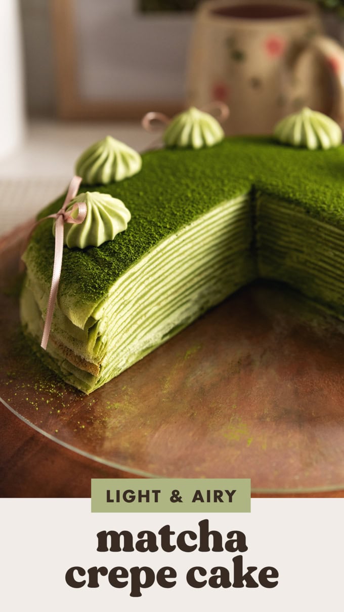 A close-up cross-section of a matcha mille crepe cake to show the many layers of crepes and whipped cream inside.