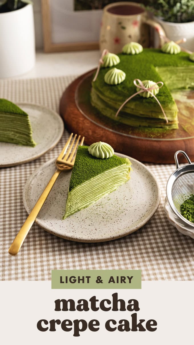 A slice of matcha mille crepe cake on a plate with a fork in front of the rest of the crepe cake.