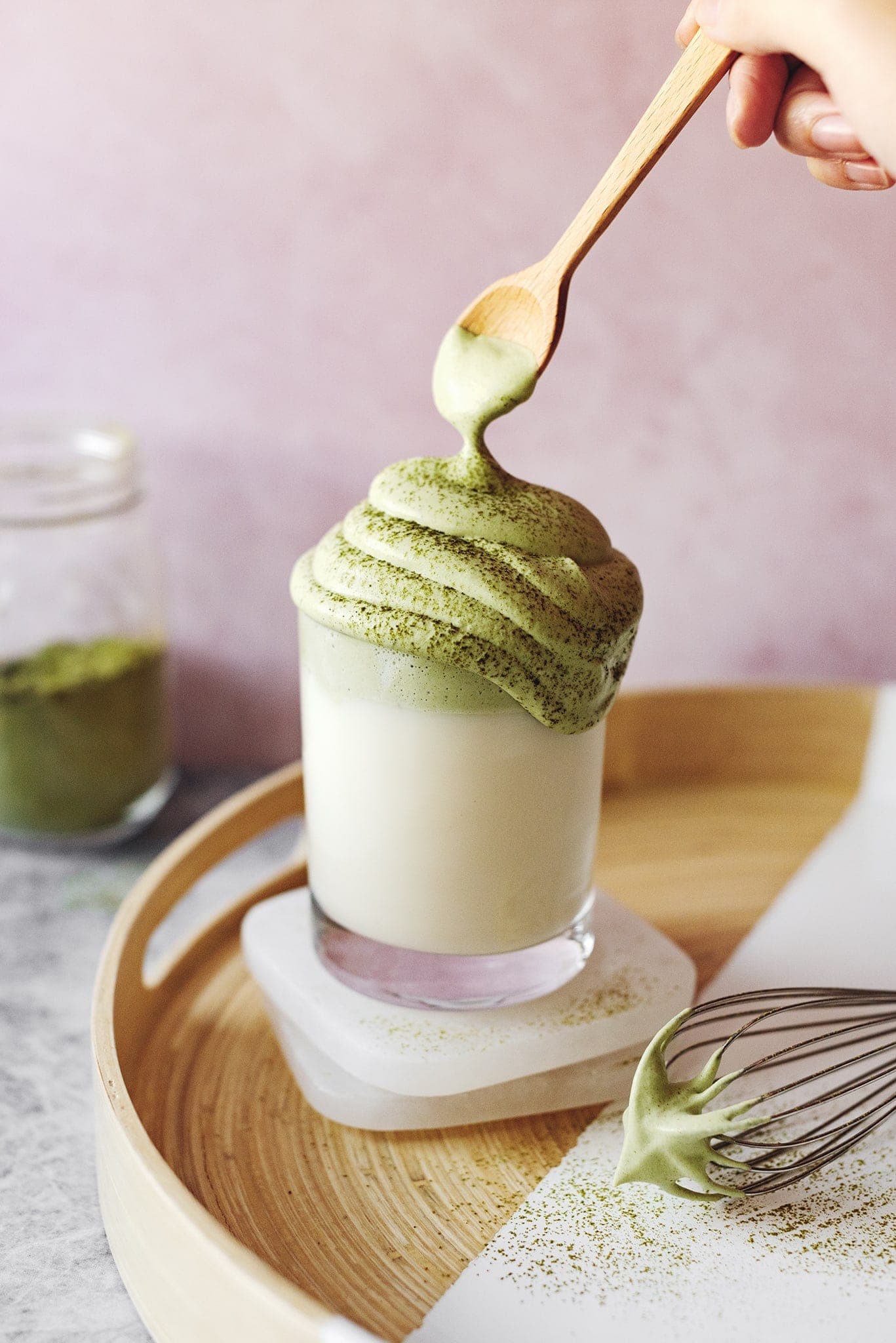 Spoon lifting whipped matcha cream from dalgona matcha latte