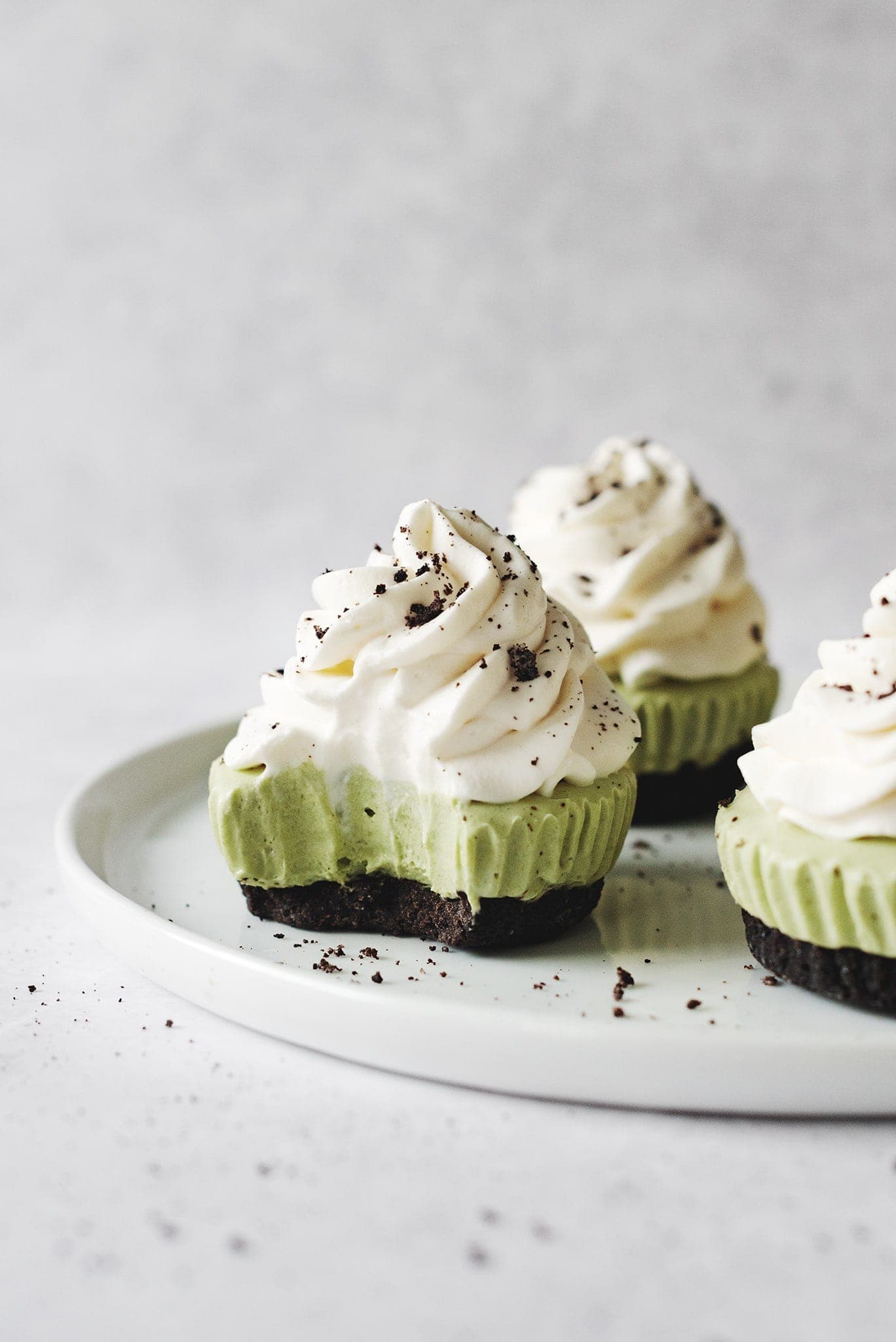A bite taken out of a mini matcha cheesecake