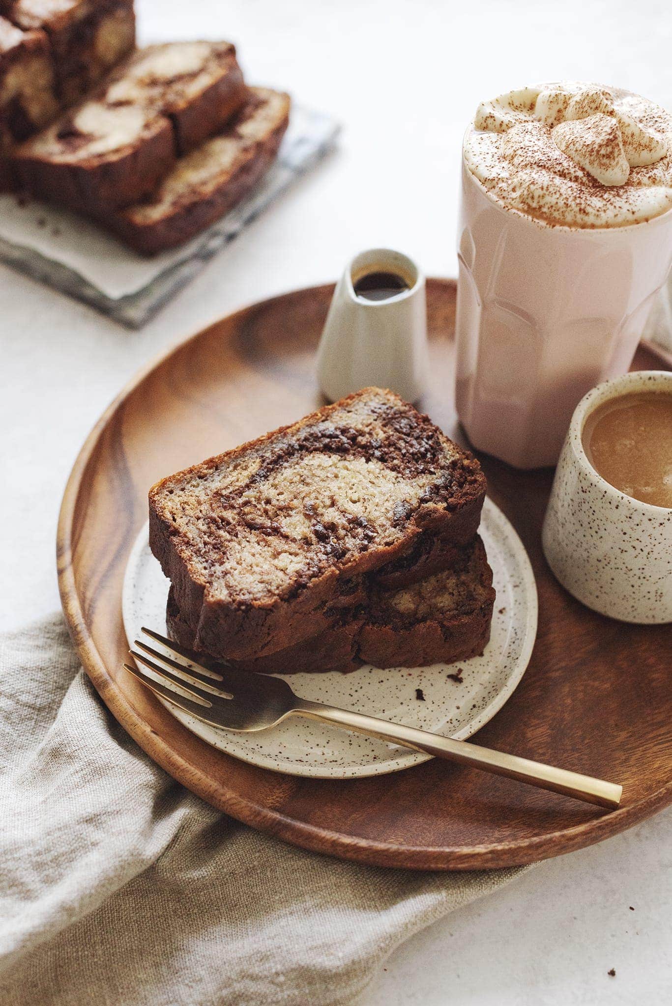 Stack of banana bread slices on wood platter