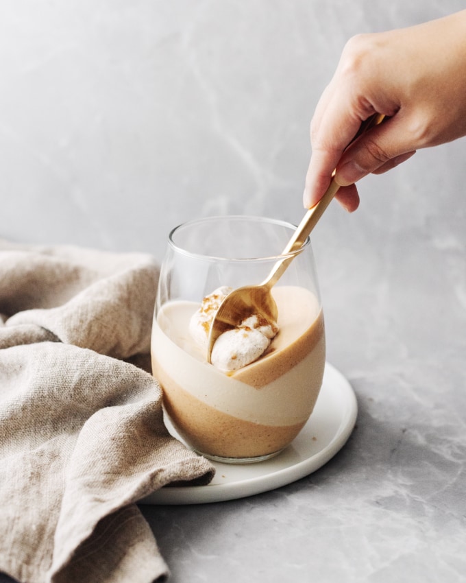 Spoon scooping up panna cotta in glass