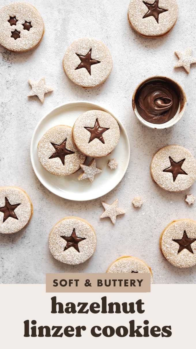 Hazelnut linzer cookies with star cutouts scattered on counter.