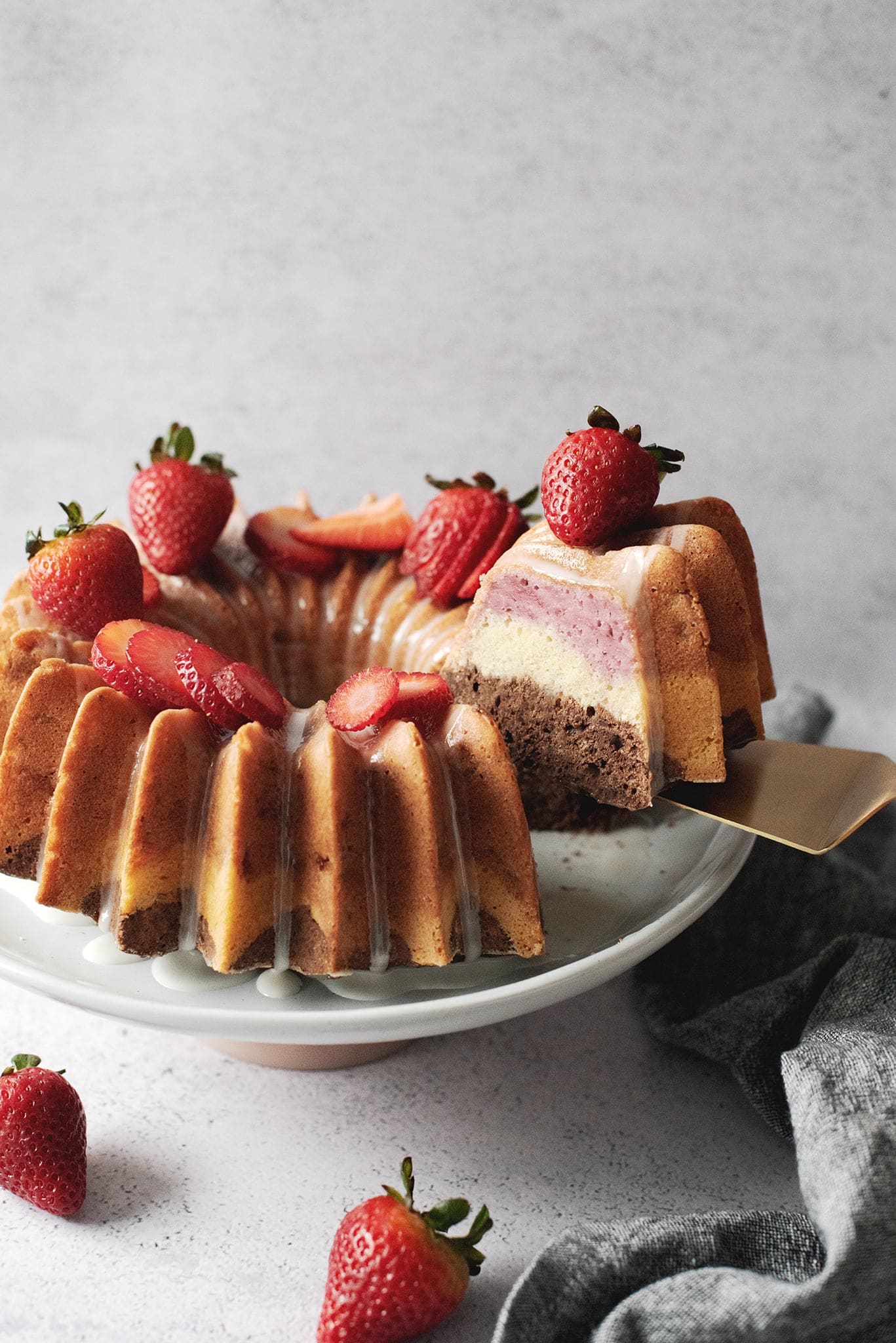 Lifting a slice of neapolitan bundt cake to show layers