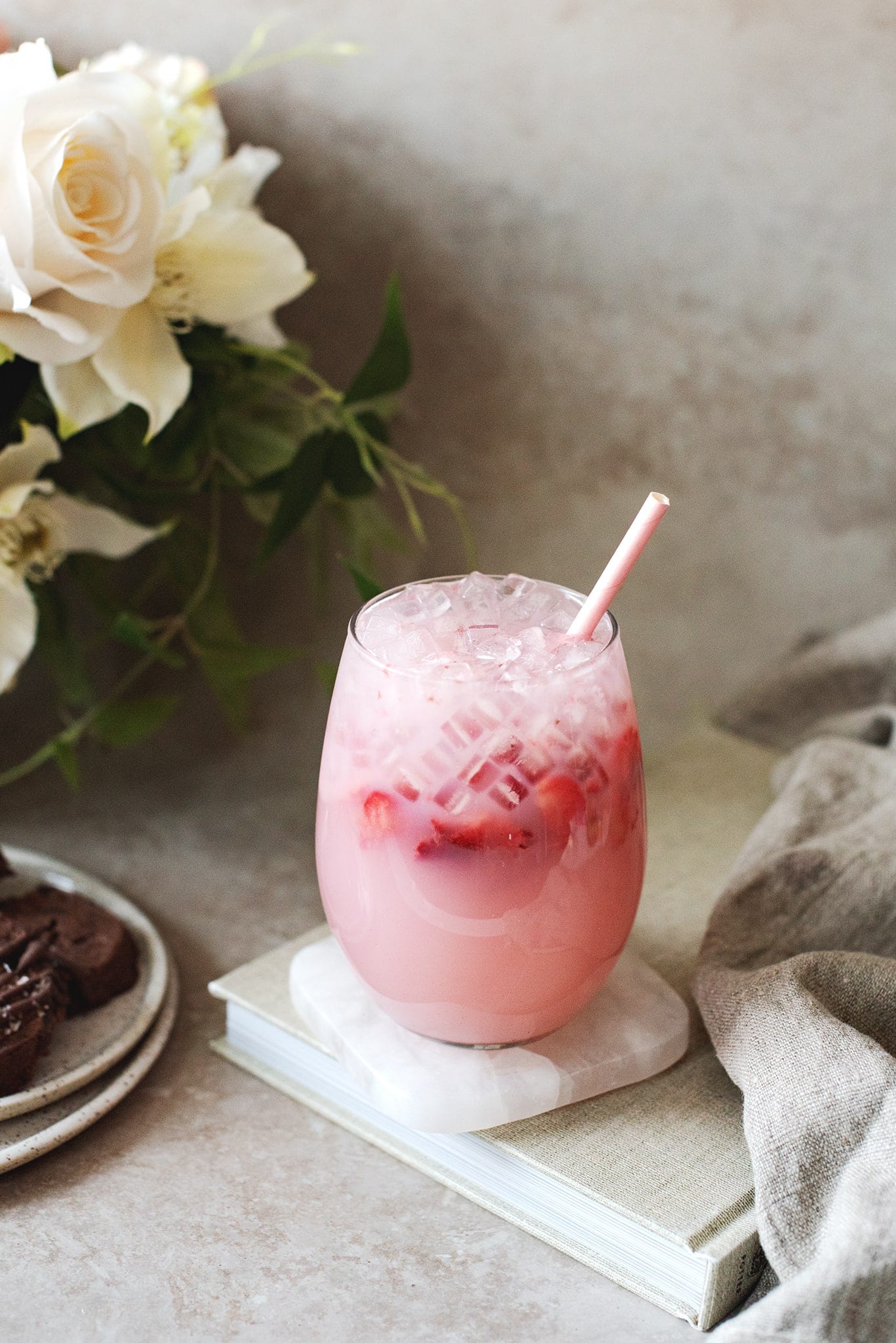 Glass of pink strawberry soju cocktail on a book