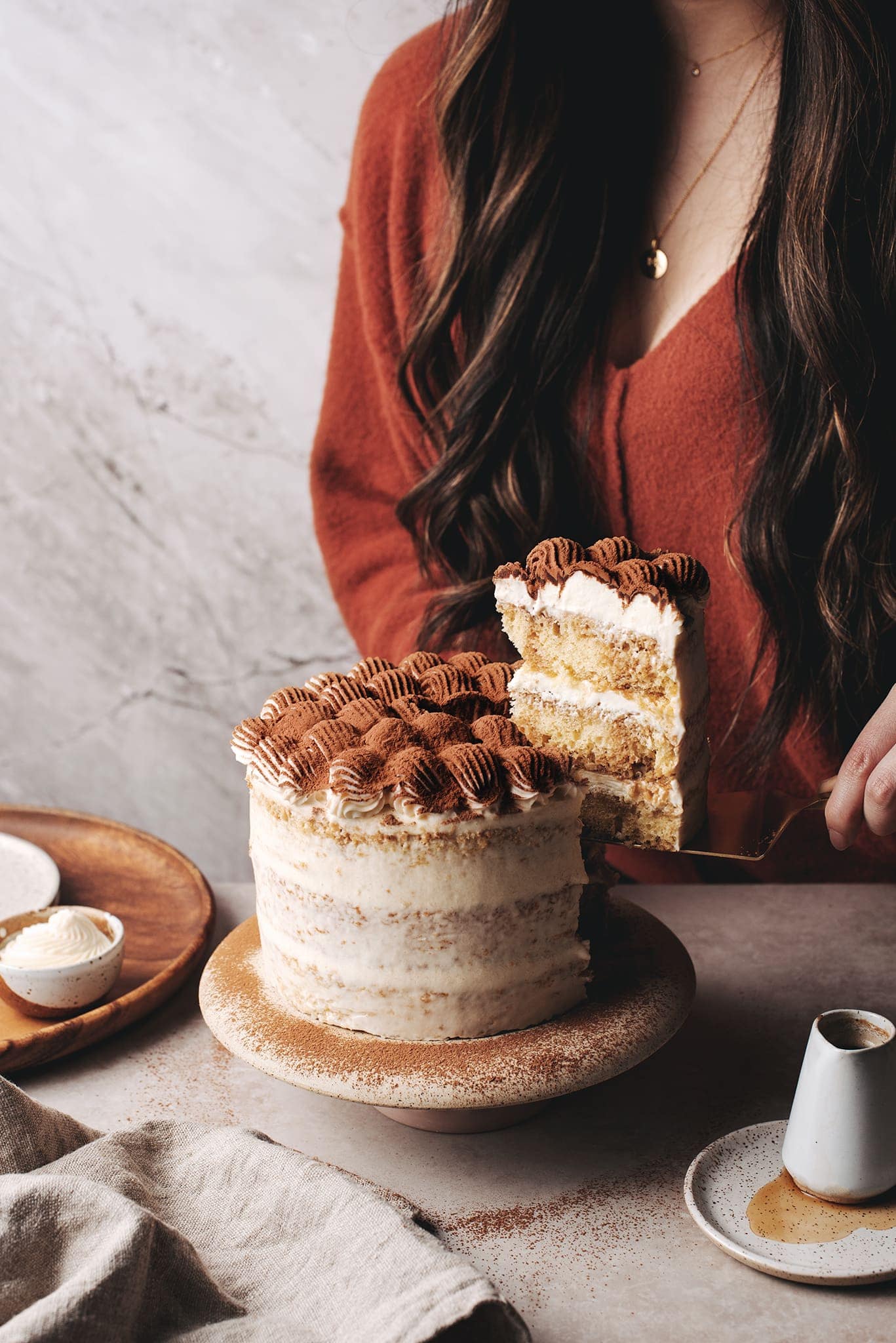 Lifting a slice of tiramisu layer cake with serving knife