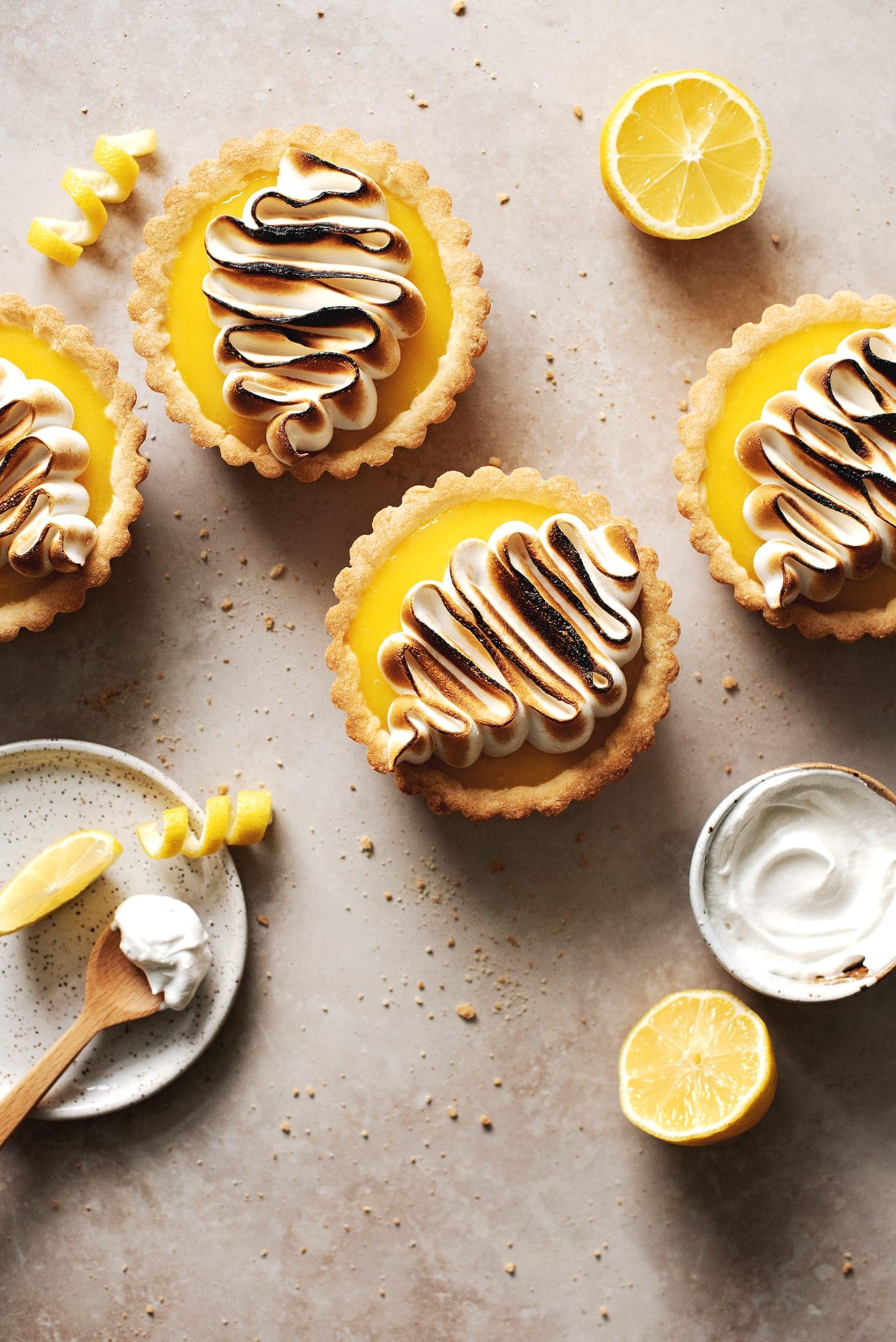 Mini lemon meringue tarts on brown surface