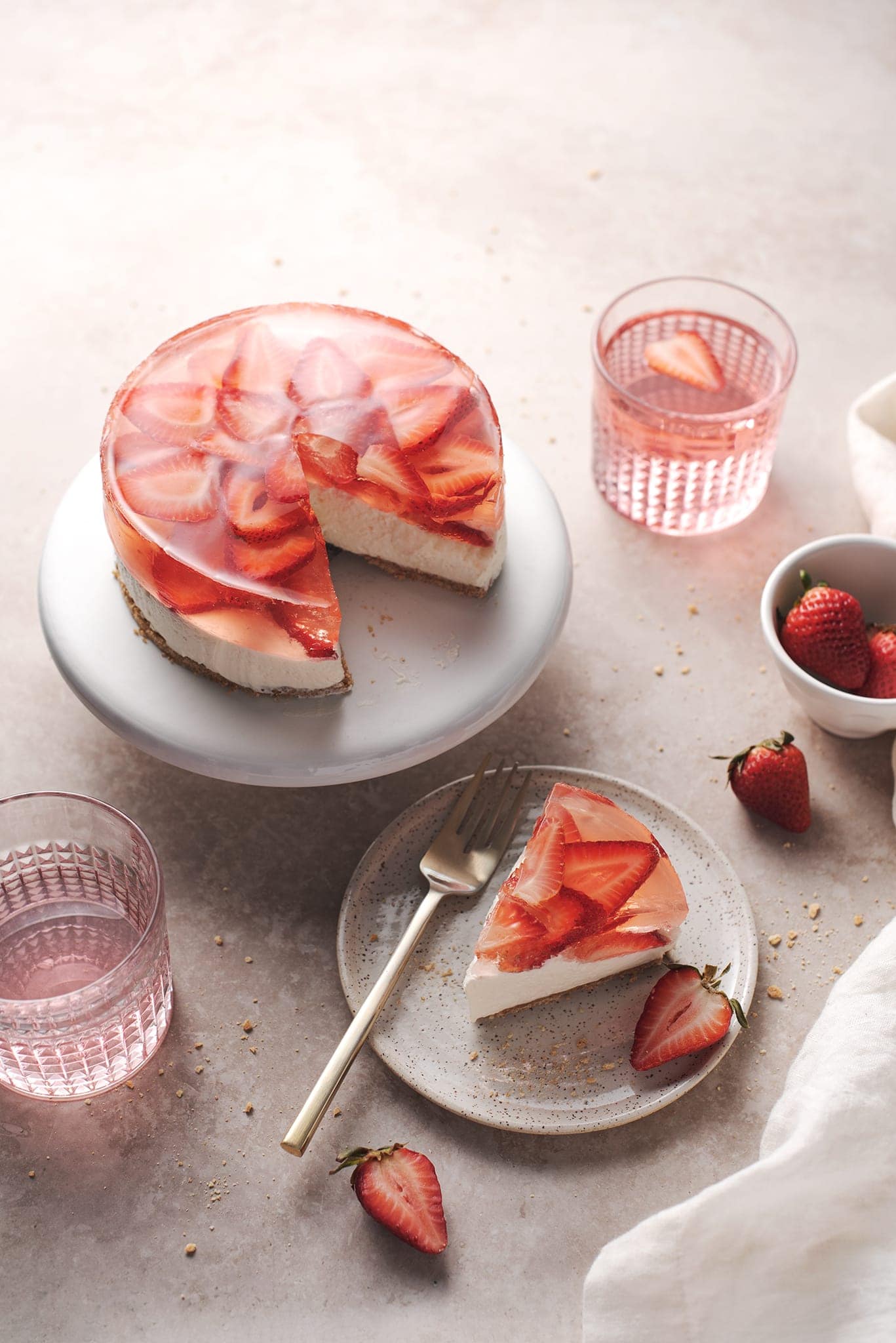 A slice of strawberry jelly cheesecake cut from the cake