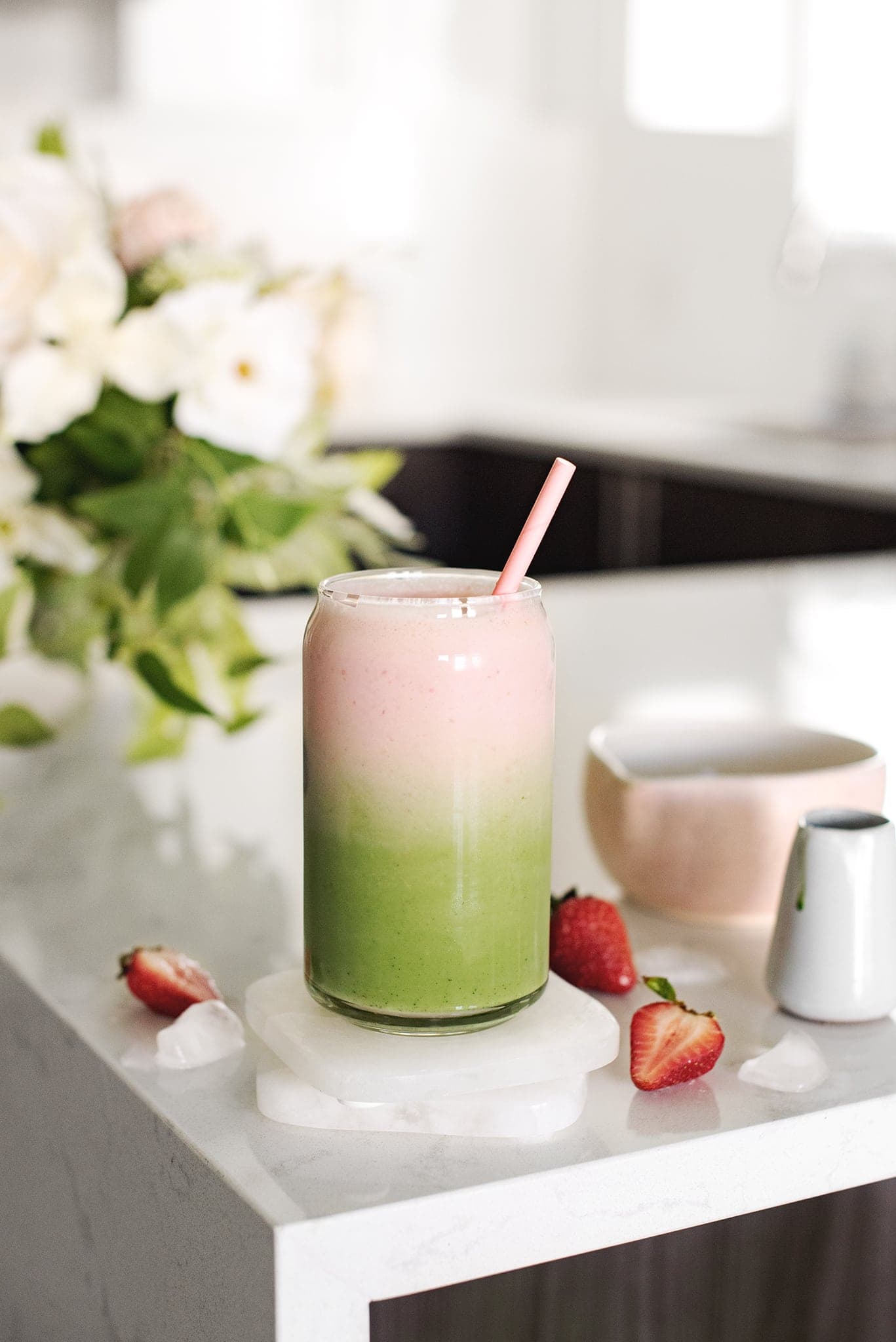 Strawberry matcha latte with green and pink layers in a glass