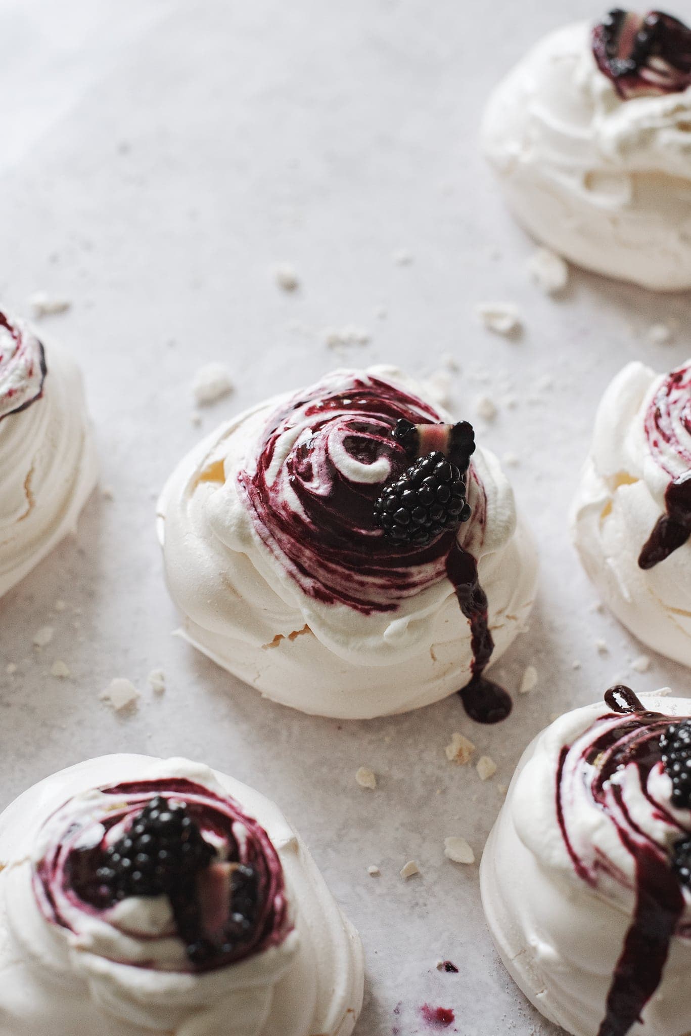 Blackberry sauce dripping down blackberry pavlova