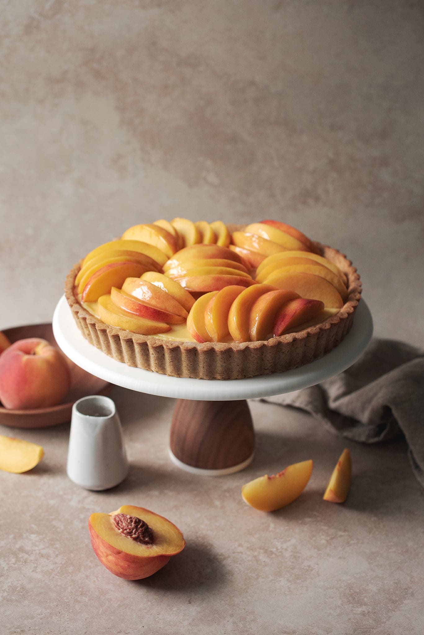 Peach custard tart on a cake stand