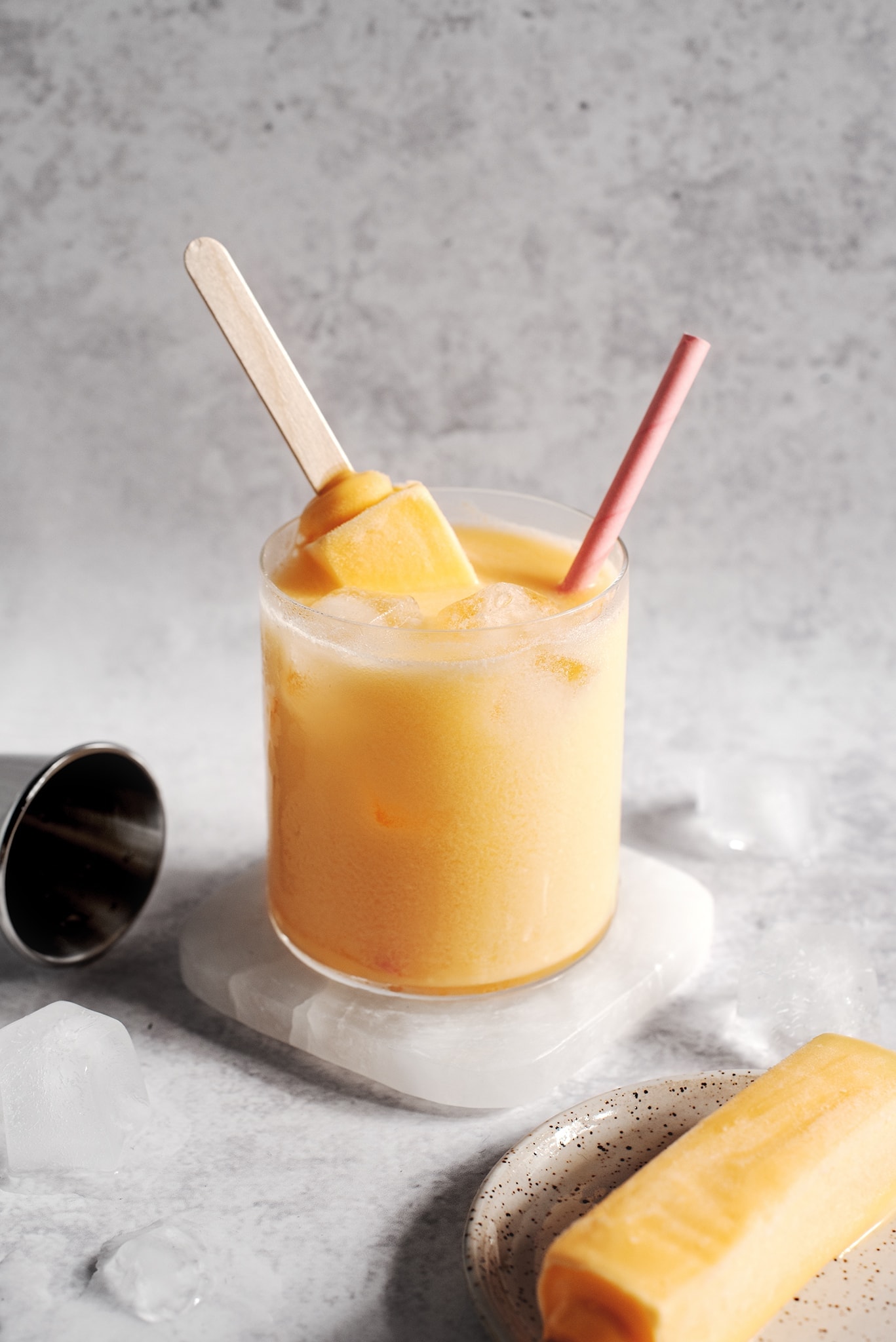 Mango melona soju cocktail with melona popsicle sticking out