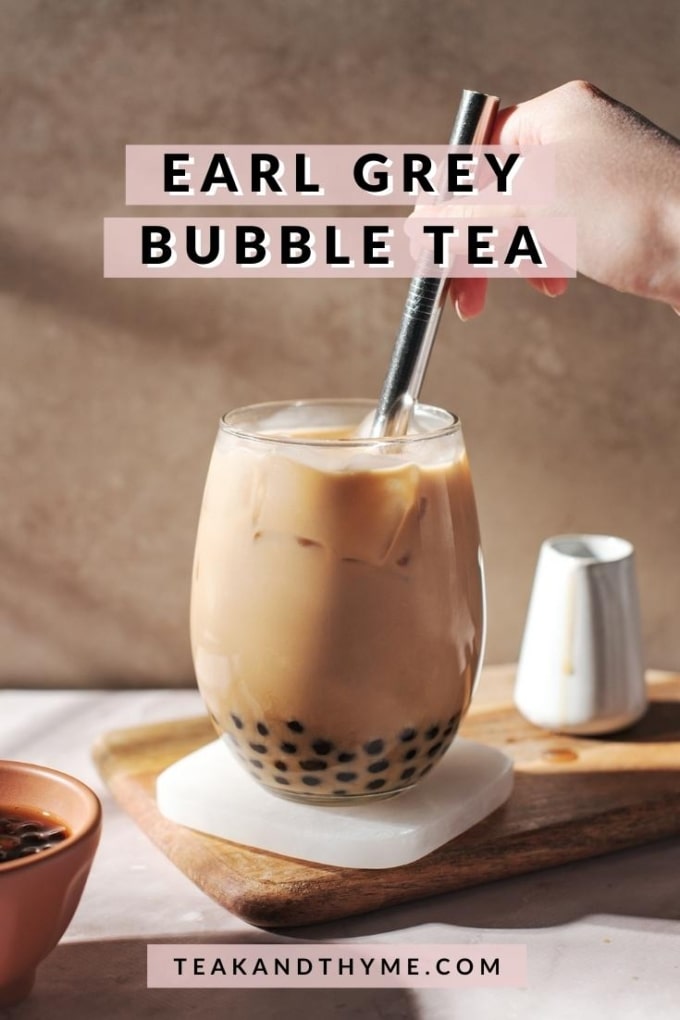 stirring a glass of earl grey bubble tea with a straw