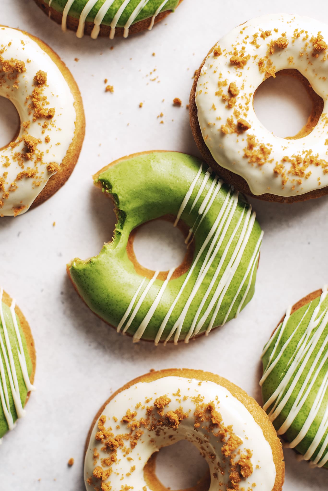 A bite taken out of a matcha mochi donut.