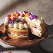 A slice of cake lifted from a lemon raspberry cake.