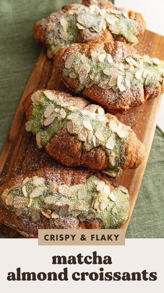 Matcha almond croissants lined up on a wooden serving board.