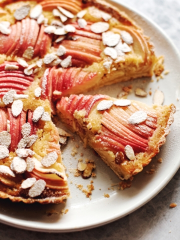 Apple and frangipane tart with a slice cut out of it