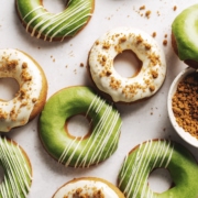 Matcha and white chocolate biscoff mochi donuts scattered on table.