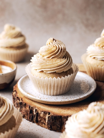 Chai spice cupcakes scattered around a wood platter
