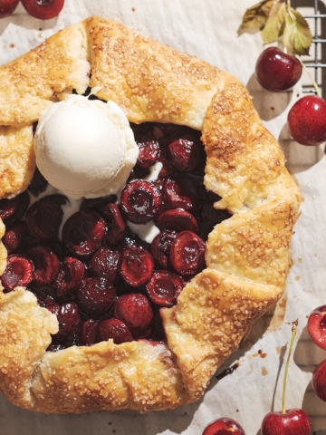 Cherry galette with a scoop of vanilla ice cream on top.
