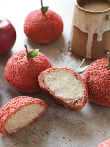Apple cream puff cut in half to show whipped cram filling inside