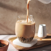 pouring a stream of milk tea into glass