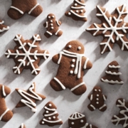 decorated gingerbread men and snowflakes on grey surface