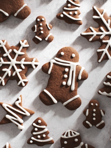 decorated gingerbread men and snowflakes on grey surface