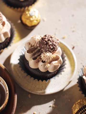 ferrero rocher cupcake on plate topped with chocolate buttercream