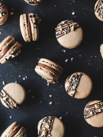 Macarons scattered on black background